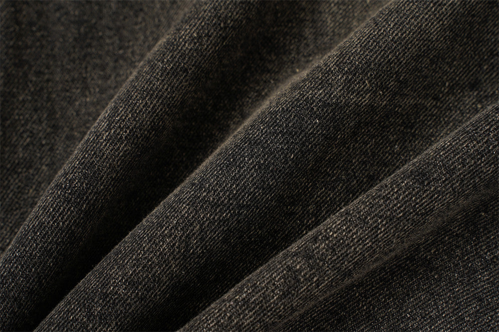 Close-up of black denim fabric texture with soft faded diagonal folds