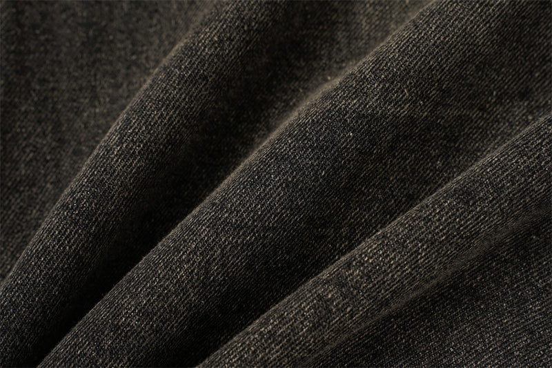 Close-up of black denim fabric texture with soft faded diagonal folds