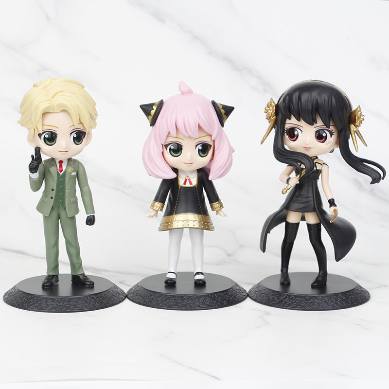 The Seakoff Spy x Family Complete Set features 15cm chibi-style PVC figures of Anya, Loid, and Yor. Displayed against a marble background, the collection showcases a blond man in a green suit, a pink-haired girl with cat ears, and a black-haired woman in a black dress with gold accents on individual bases.