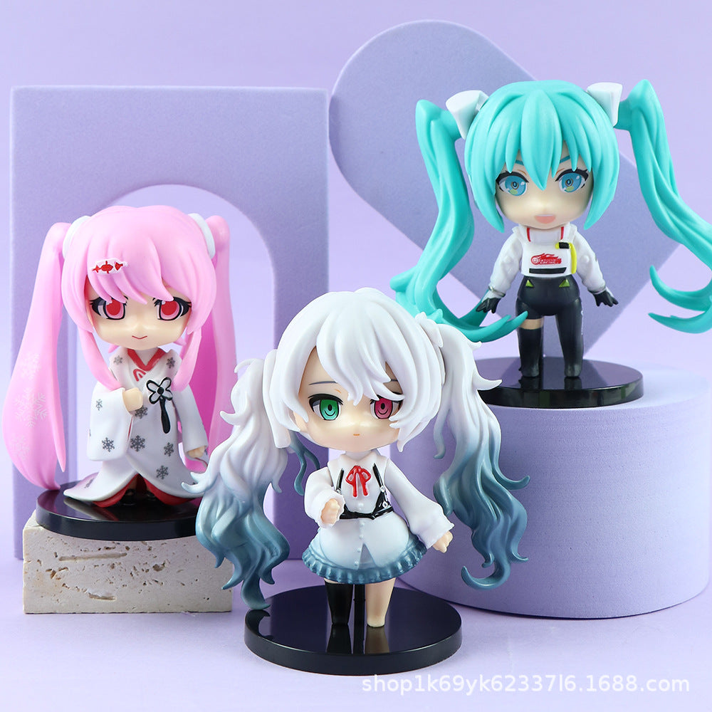 Displayed against a purple backdrop, the Hatsune Miku Kimono Figures feature a pink-haired figure on a block, alongside teal-haired and white-haired figures with pigtails from the 6-piece set, all with removable heads for customization.