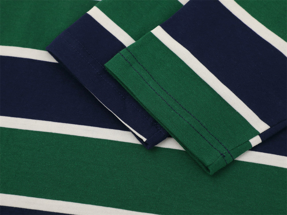 Close-up of striped sleeve cuffs on green and navy rugby polo shirt
