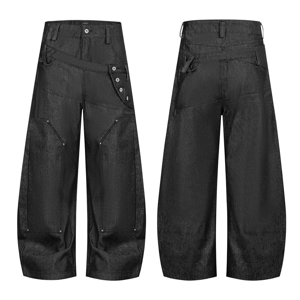 Jean homme noir enduit à jambes larges, avec double ceinture, empiècement diagonal et fermeture asymétrique à patte boutonnée, vue de face et de dos