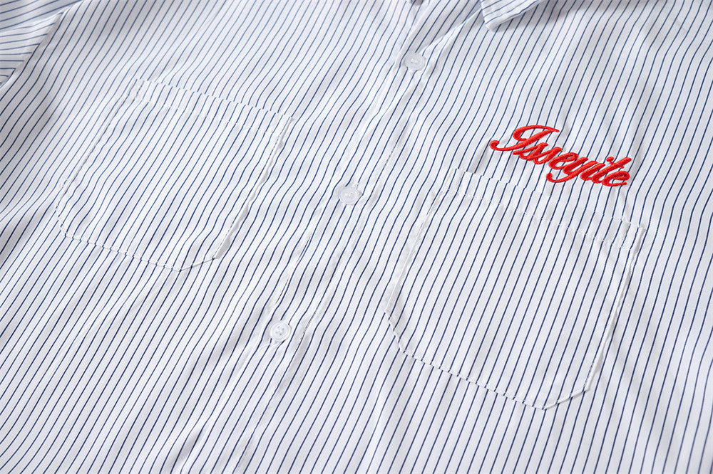 Close-up of striped shirt front with button closure, chest pockets, and red chest embroidery