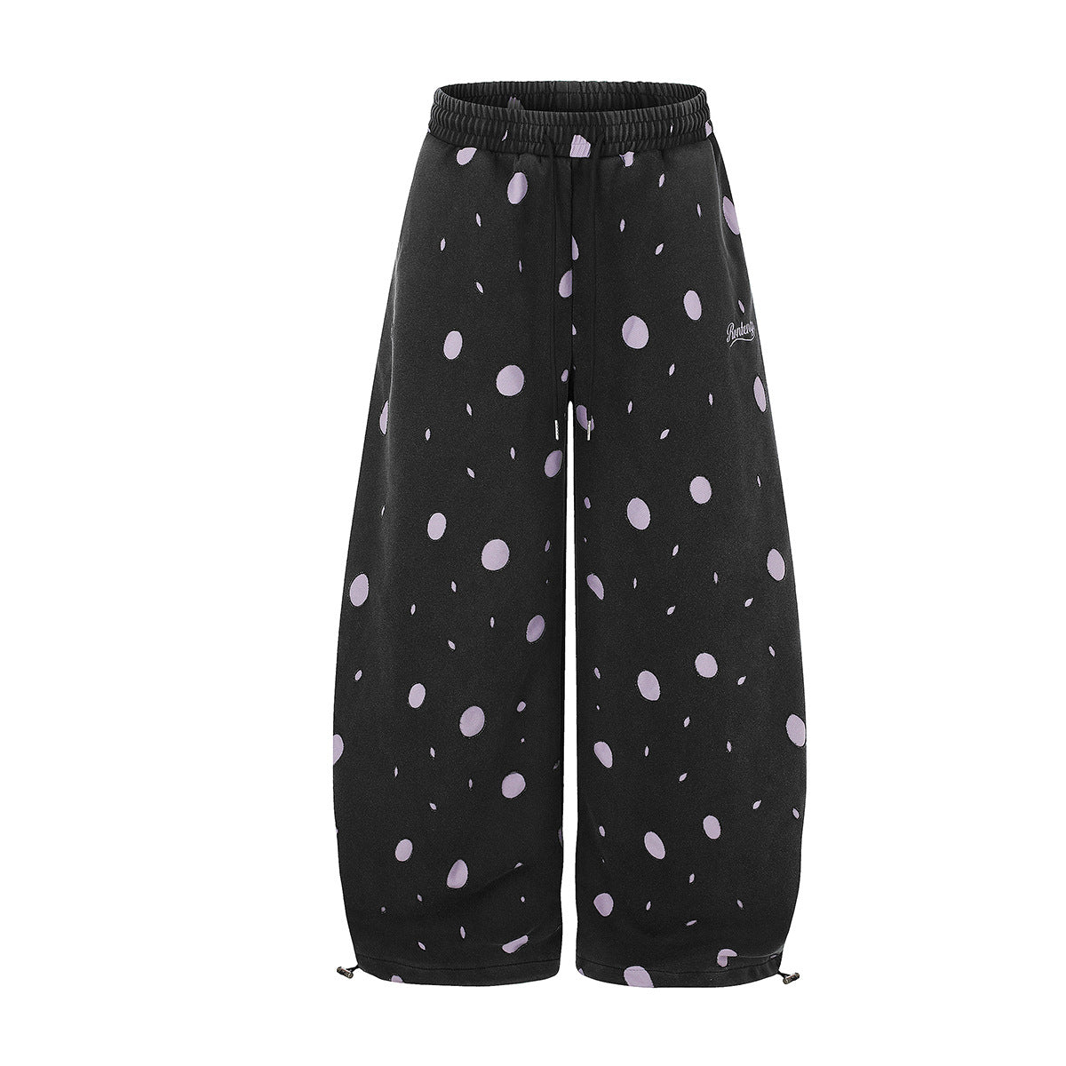 Wide-leg black sweatpants with lavender polka dot print, elastic drawstring waist, and adjustable ankle toggles, shown front