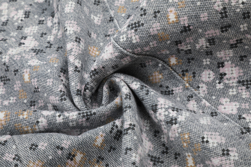 Close-up of twisted gray floral print fabric with pink and gold flecks