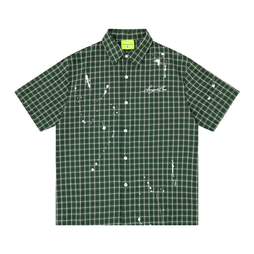 Oversized paint splatter plaid short sleeve shirt in forest green with white drip graphic and script logo