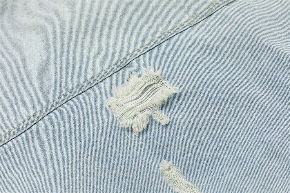 Close-up of a large frayed distressed patch on the light wash denim jacket
