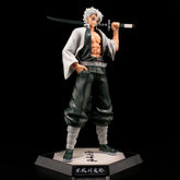 The Shinjuro Rengoku Demon Slayer PVC Figure is a 29cm high-quality collectible. It features spiky white hair, a dark green and white outfit with bandaged limbs, and traditional footwear, holding a sword over his shoulder. The figure stands on a hexagonal base with text.