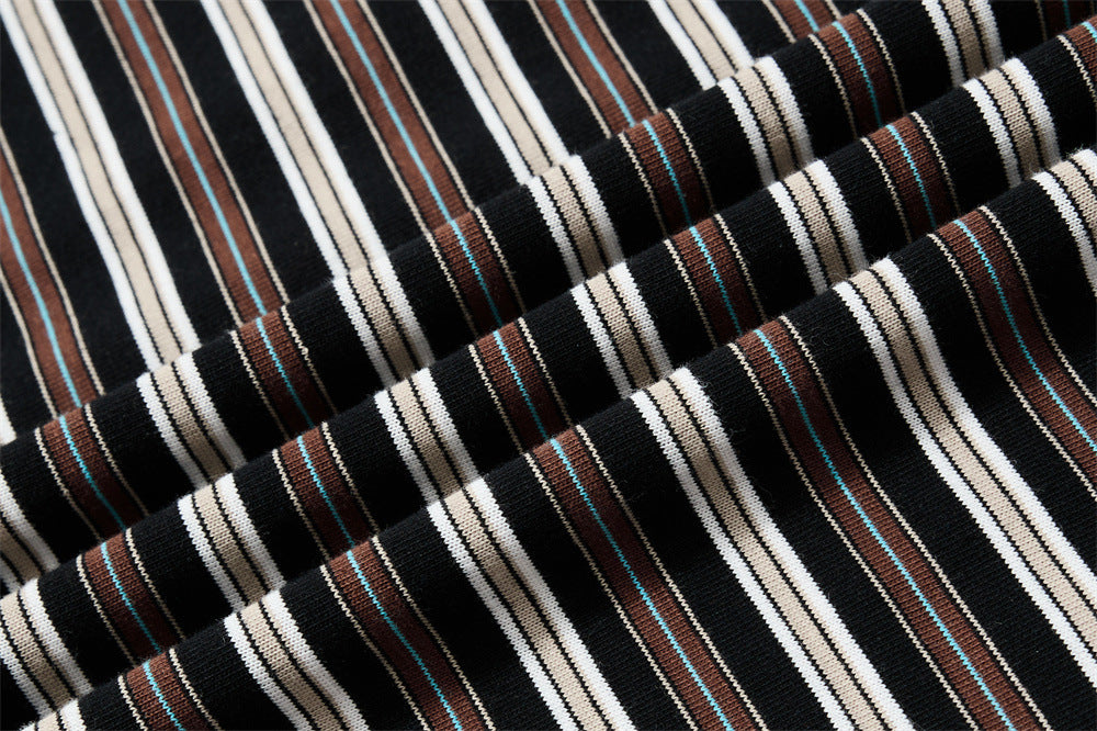 Close-up of ribbed striped knit fabric in black, cream, brown, and blue trim