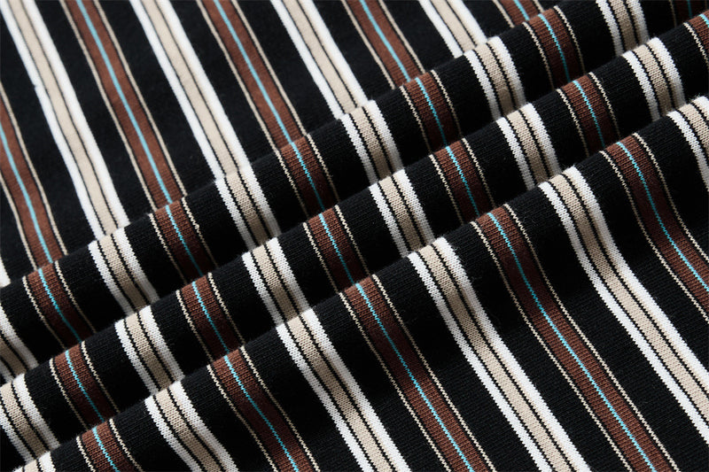 Close-up of ribbed striped knit fabric in black, cream, brown, and blue trim