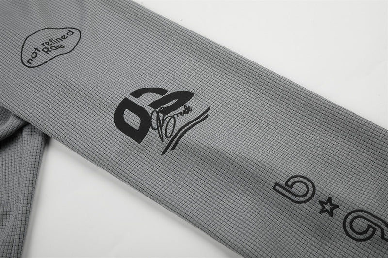 Close-up of gray sleeve with 02 graphic and not refined rain text
