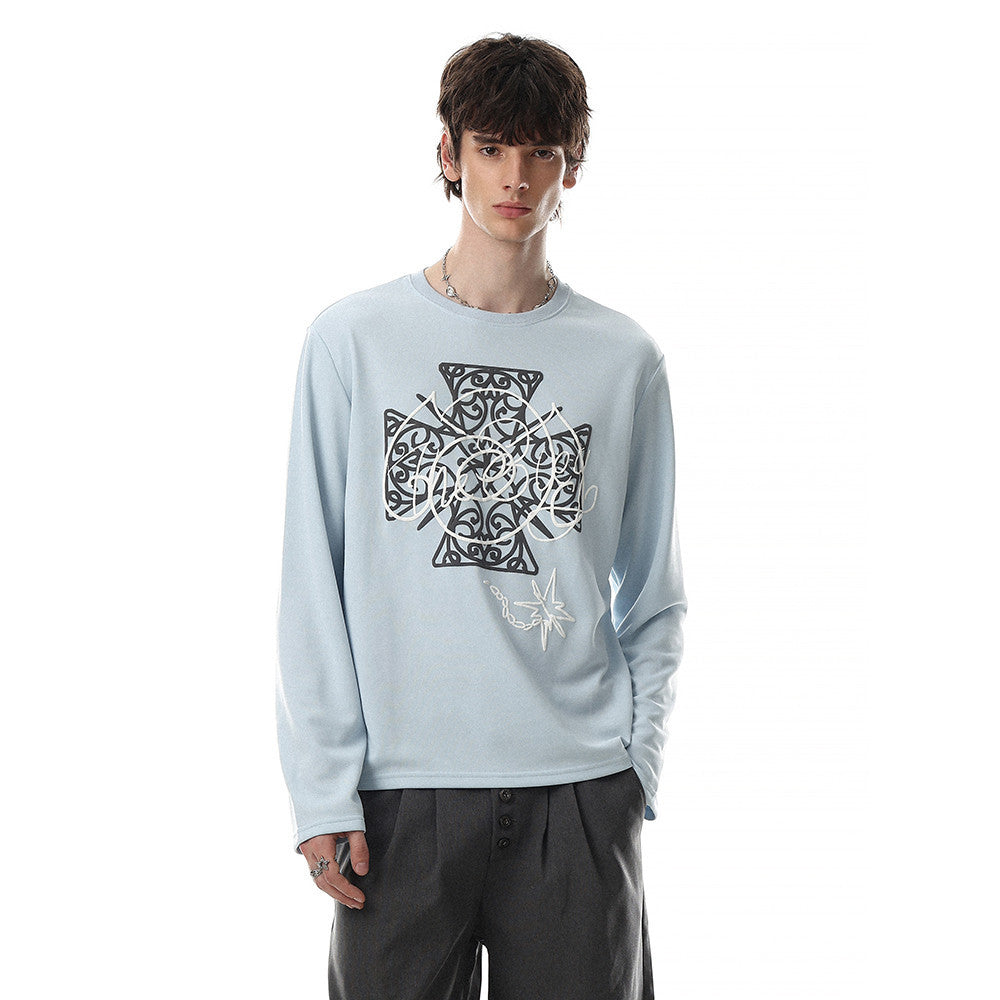 Model wearing light blue long sleeve tee with Celtic cross graphic print and crew neck