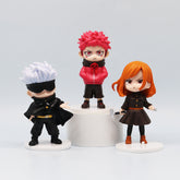 The Jujutsu Kaisen Q Edition Spell Return 7-Piece Set showcases three chibi-style PVC figures on stands: one with silver hair and a black blindfold, another with fiery red hair in a hoodie, and an orange-haired figure in a brown dress, all displayed perfectly on a small pedestal.