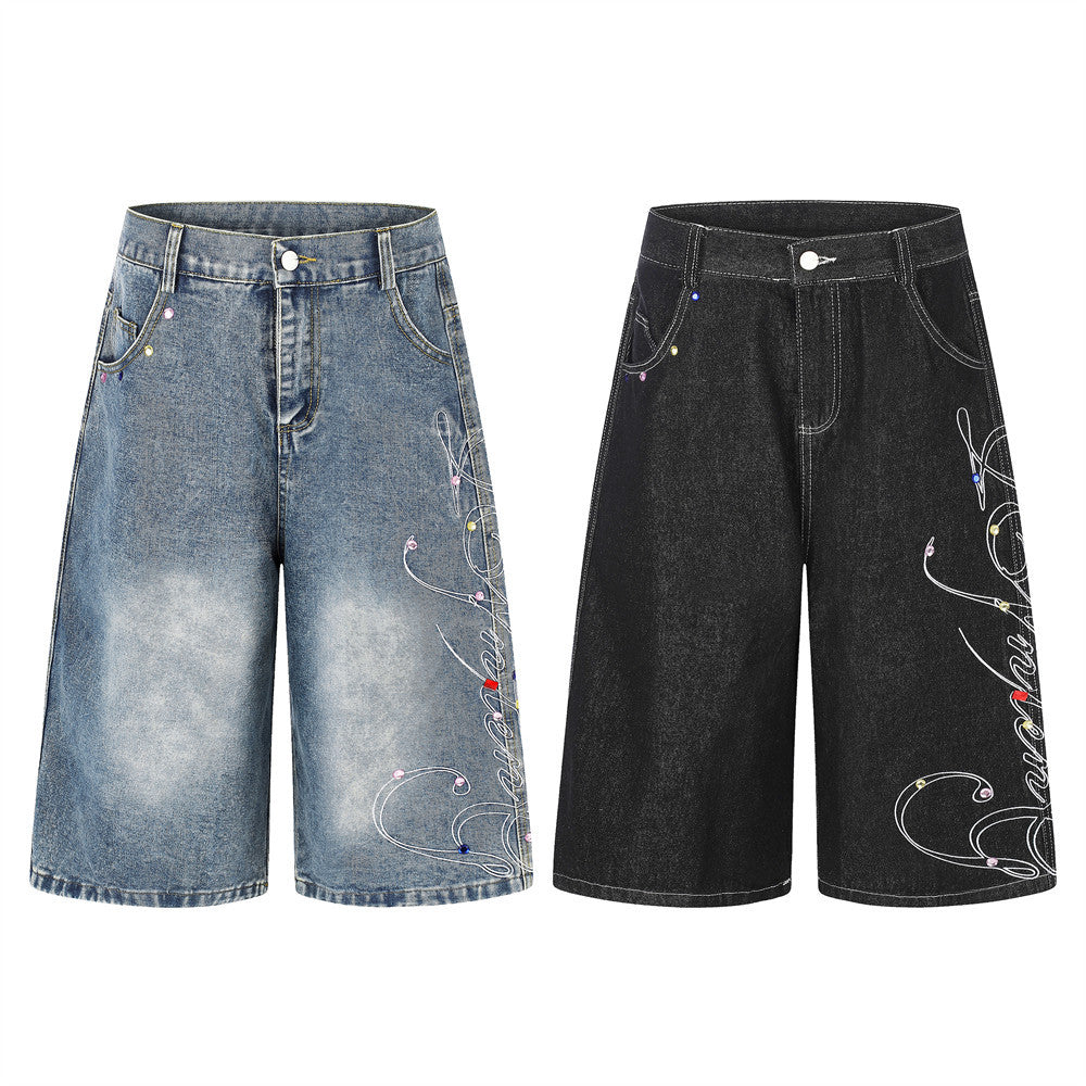 Men's wide leg denim shorts with white script embroidery and multicolor rhinestone studs in washed blue and black colorways