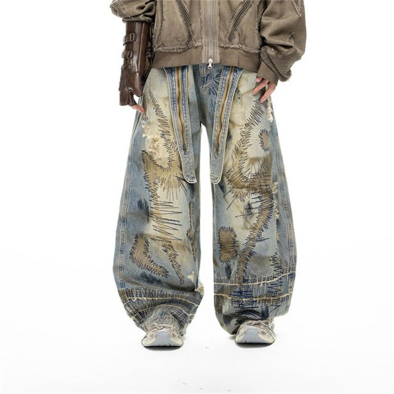 Baggy wide-leg distressed jeans with chaotic embroidery, bleach-wash dirty-dye treatment, and decorative exposed zippers on t