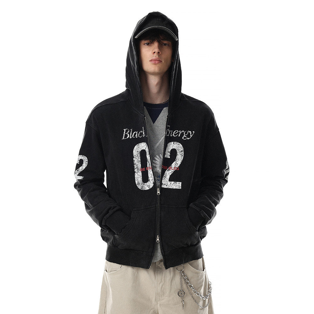 Model wearing black distressed hoodie with hood up and hands in pockets, front view