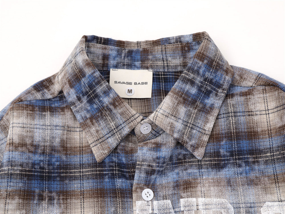 Close-up of shirt collar and top button on blue plaid flannel