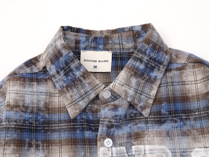 Close-up of shirt collar and top button on blue plaid flannel