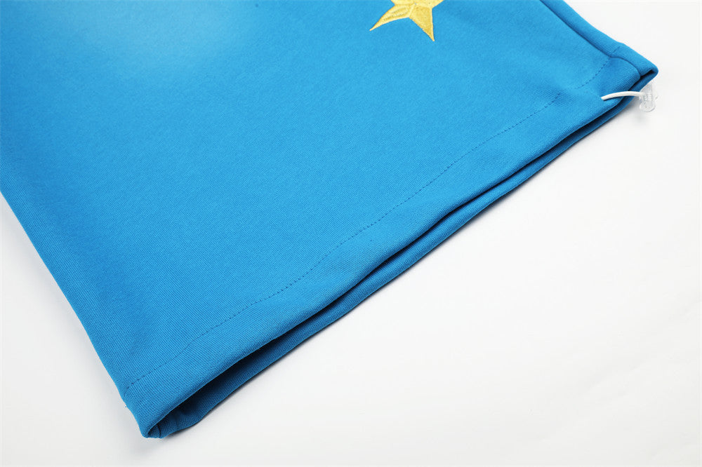 Close-up of blue sweatpants hem and side seam with star detail