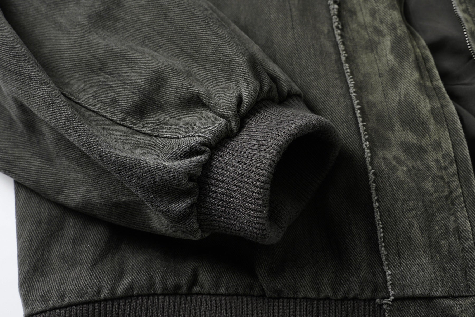 Veste bomber en jean délavé déconstruite à empiècement croisé et coutures effilochées