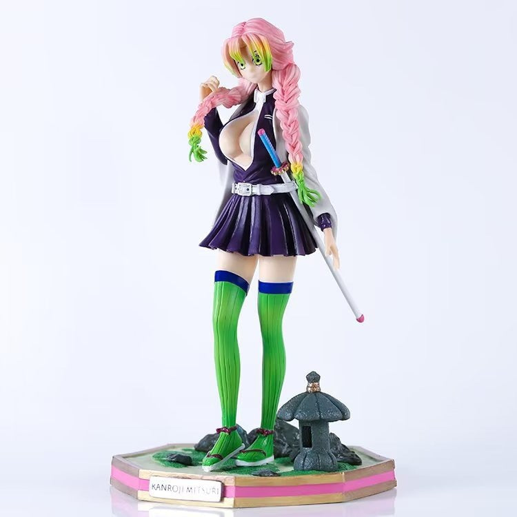 This Kanroji Mitsuri Action Figure by Demon Slayer features the pink and green-haired character in a white top, black skirt, and green thigh-high socks, wielding a sword on a base labeled &quot;Kanroji Mitsuri.&quot; At 25cm tall, this high-quality design is an essential collectible.