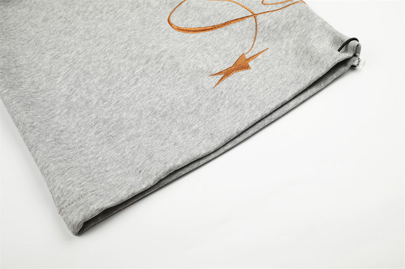 Close-up of gray sweatpants hem and star print detail