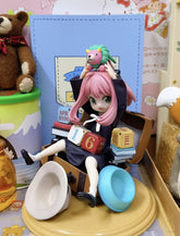 The Spy x Family Anya Forger 16 cm PVC figure features a girl with pink hair in a charming sitting pose, accompanied by a lion toy. She sits on a yellow circular base with a small creature perched on her head, encapsulating the character&