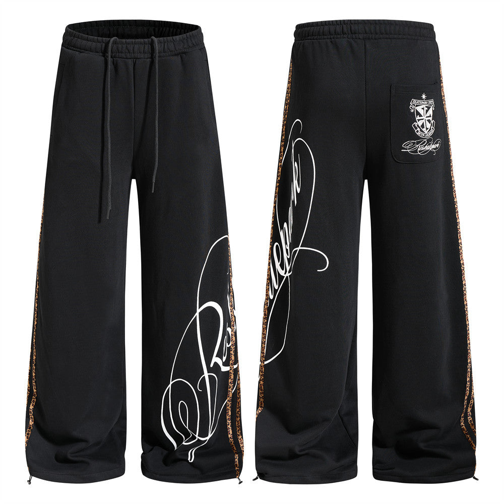 Black wide-leg sweatpants with leopard side tape and white cursive script graphic print, front and back view