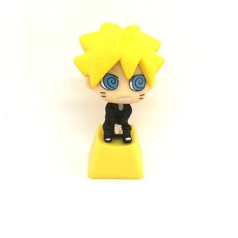 A small figurine resembles Naruto characters, with spiky yellow hair, a black outfit, a yellow square base, large blue eyes, and a smile—similar to the charm of the Ninja Masters Keycap Set by Naruto for custom mechanical keyboards.