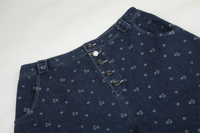 Close-up of dark blue denim waistband with floral print and button fly