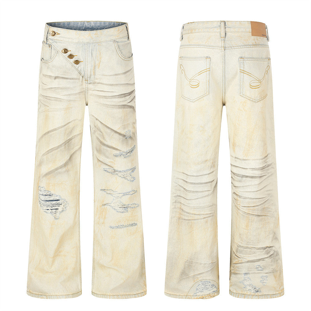 Men's wide-leg distressed jeans in cream beige mud-dye wash with ripped tear-outs and diagonal button fly, front and back vie