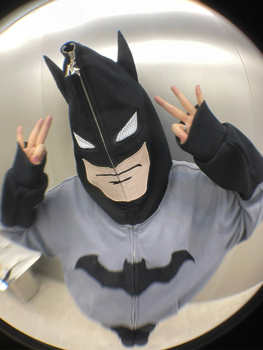 Wearing a Seakoff Batman-Inspired Hoodie, 400GSM oversized grey and black zip-up, they pull the hood tight like a mask. Flashing peace signs, they capture the playful distortion of a fisheye lens—an iconic nod to superhero streetwear vibes.