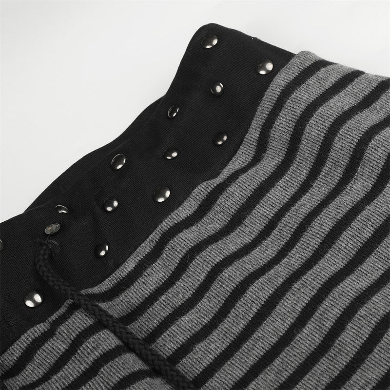 Studded black waistband and striped knit fabric on wide-leg pants, close-up detail