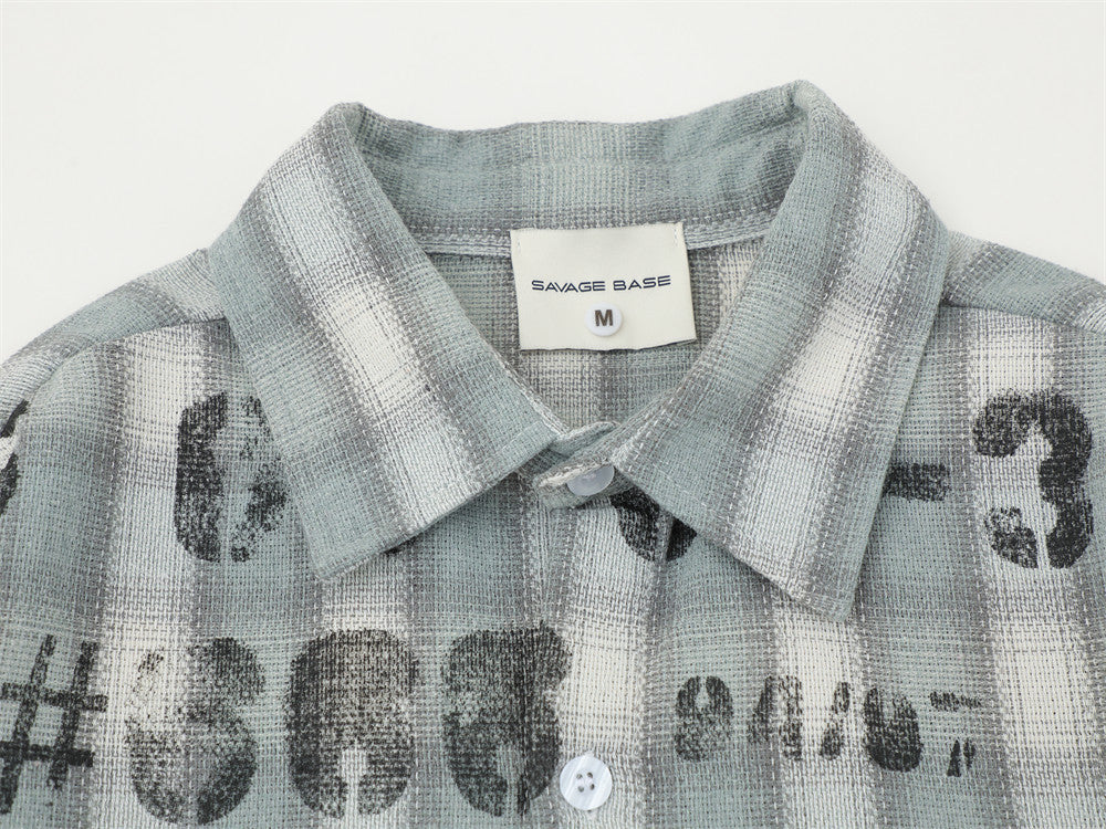 Close-up of the collar on a light gray plaid shirt with distressed print and brand label