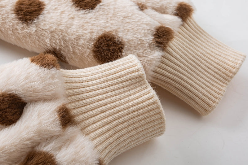 Close-up of cream ribbed jacket cuffs beside brown polka dot faux shearling sleeves