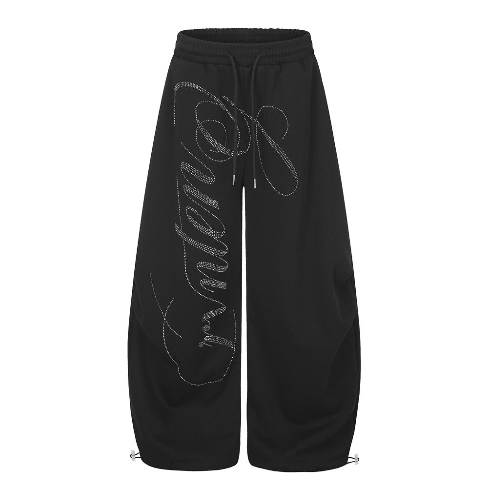 Pantalones de chándal extragrandes de pierna ancha con gráfico caligráfico de strass en la parte frontal de la pernera, en negro y gris