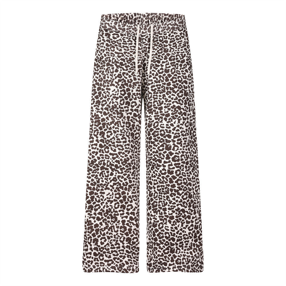 Men's leopard print wide-leg sweatpants with drawstring waist and pink script logo on outer leg