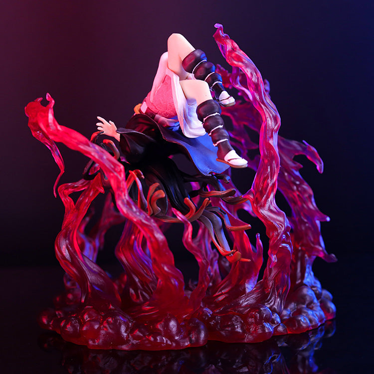 The Nezuko Explosion Pose action figure from Demon Slayer displays dynamic artistry, with swirling translucent red blood effects. This premium figure appears mid-air in a black and purple outfit with white shoes against a dark backdrop that accentuates its vibrant elements.