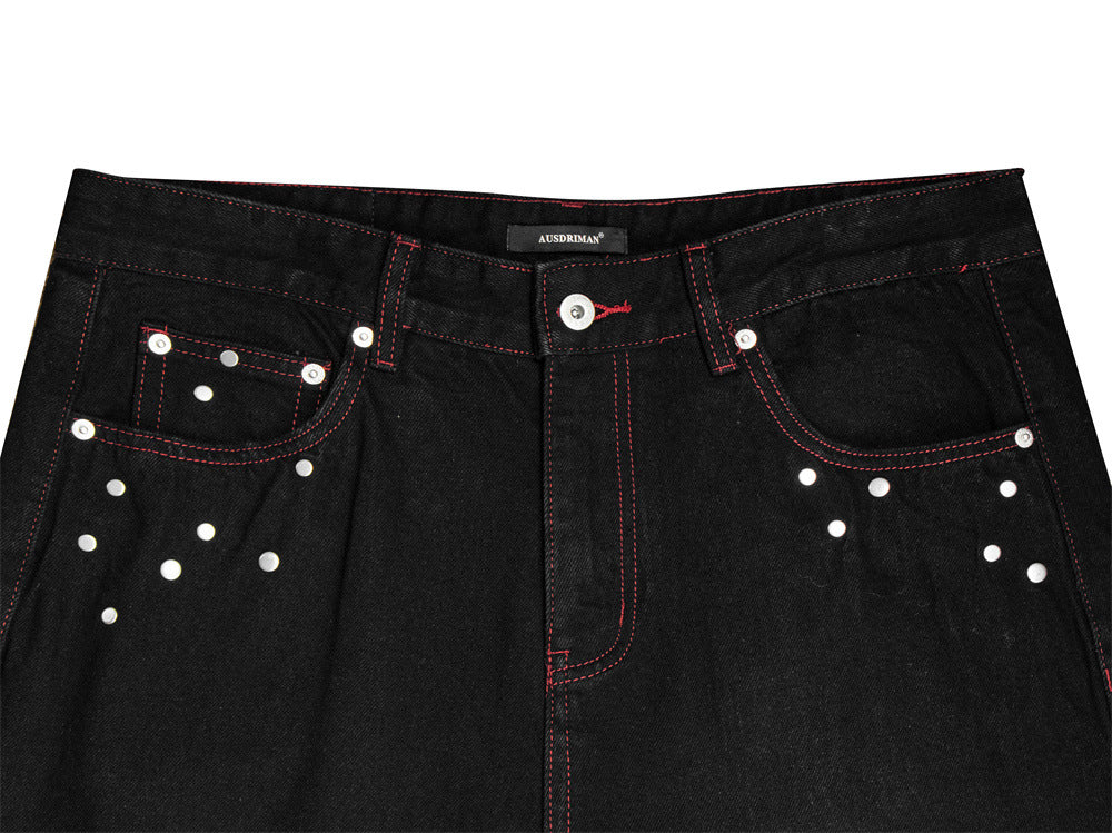 Jean homme noir à jambes larges, surpiqûres rouges contrastées, broderie étoile et clous