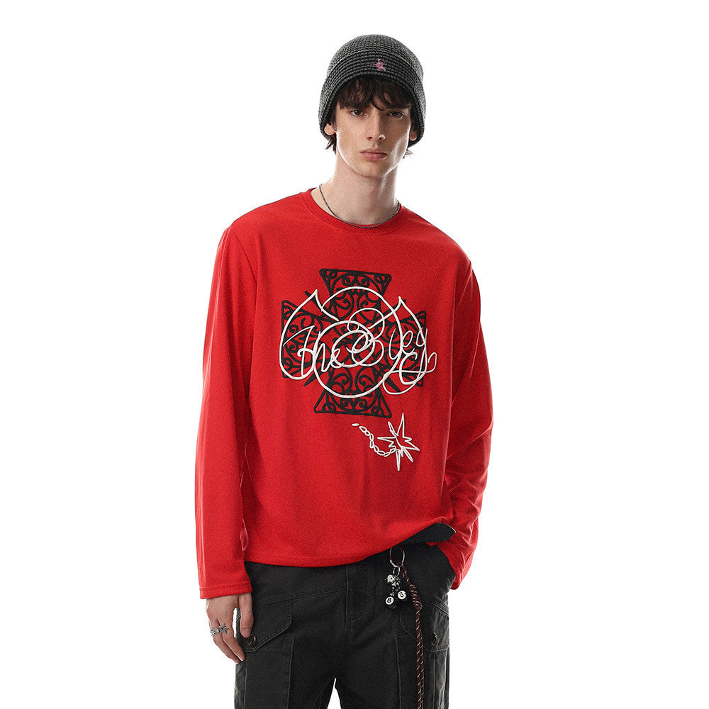 Model wearing red long sleeve tee with Celtic cross graphic print, paired with black pants and beanie