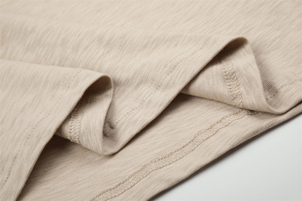 Close-up of beige long sleeve tee hem and seam stitching