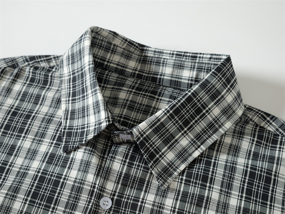 Close-up of black plaid shirt collar and top button on a button-up neckline