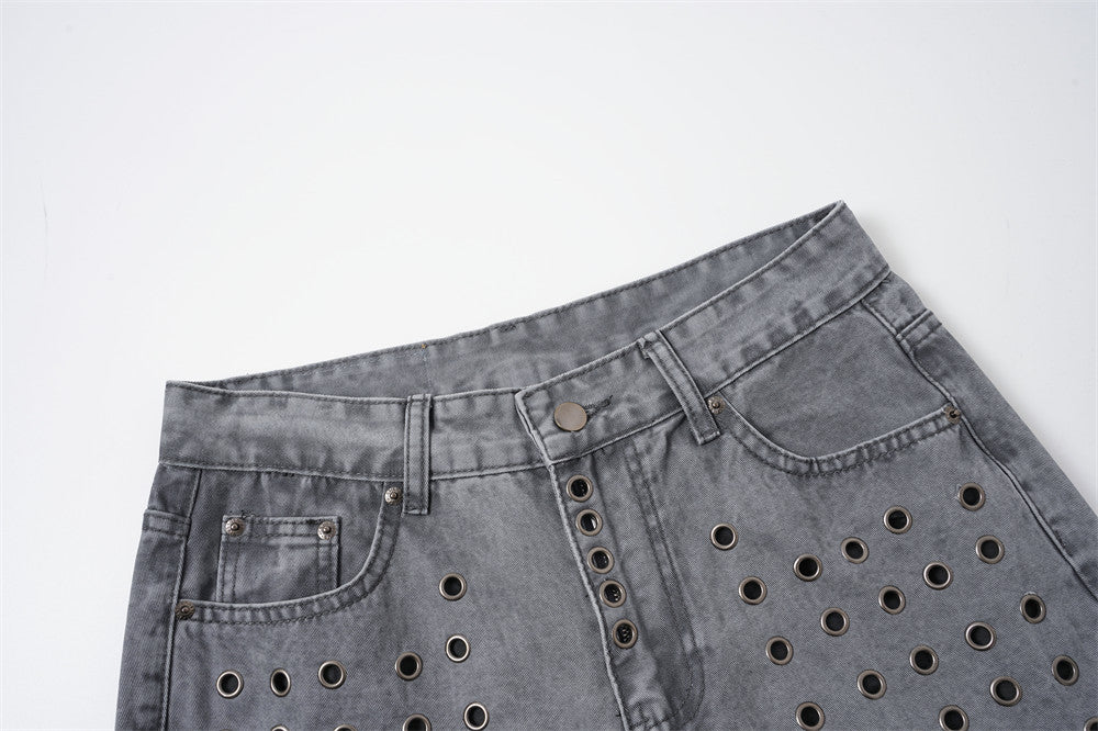 Close-up of washed grey jeans showing the front waist, button fly, and metal eyelet detail