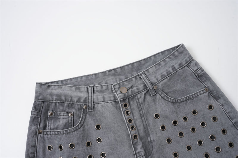 Close-up of washed grey jeans showing the front waist, button fly, and metal eyelet detail