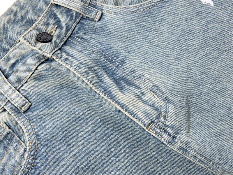 Close-up of front pocket seam and paint-washed denim texture