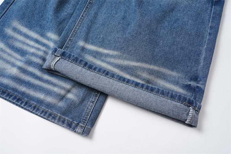 Close-up of rolled hem on blue denim pant leg with faded streaking