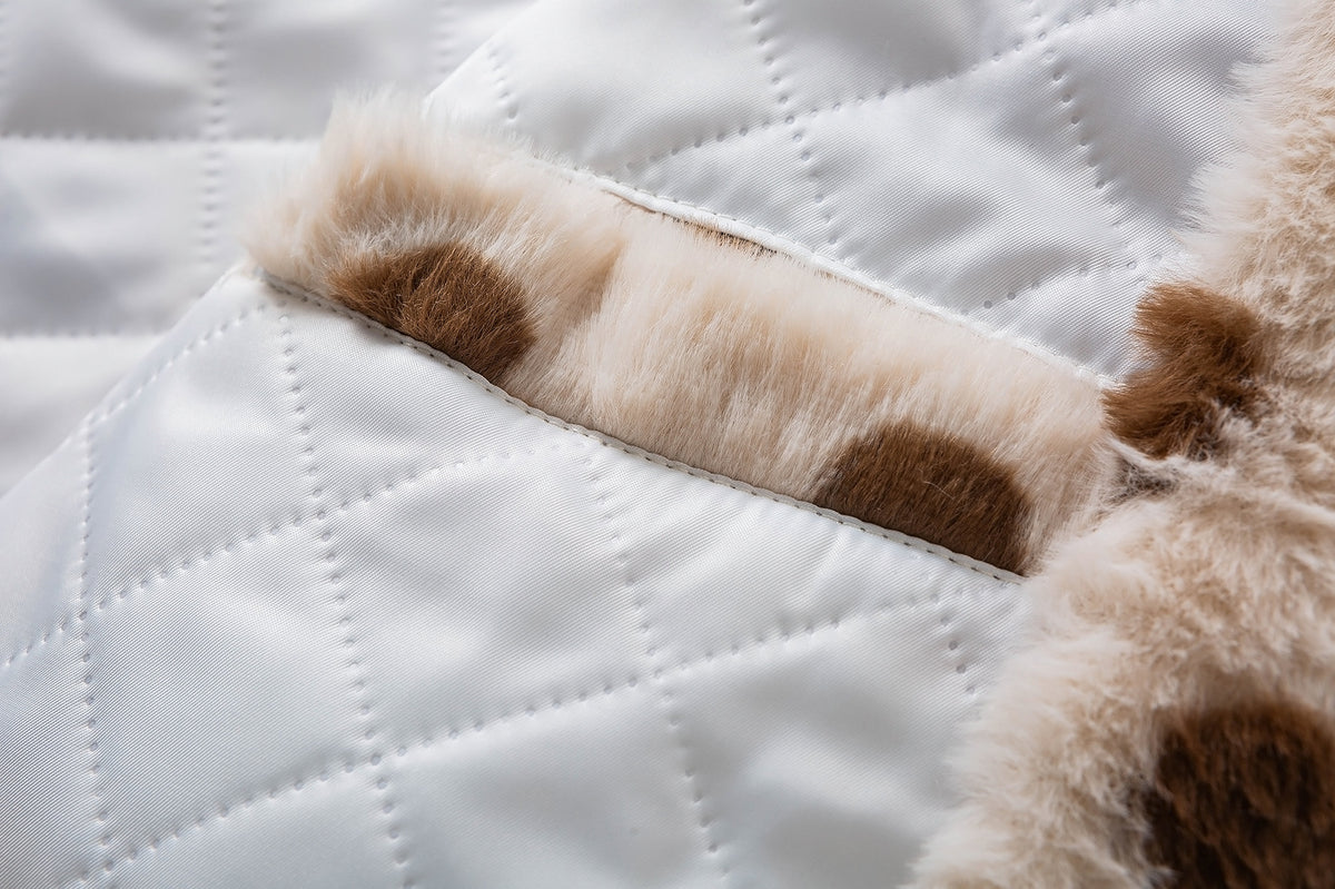 Close-up of white diamond-quilted jacket lining beside the cream and brown faux shearling exterior