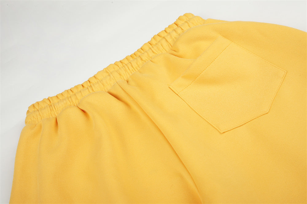 Close-up of yellow sweatpants back waistband and patch pocket