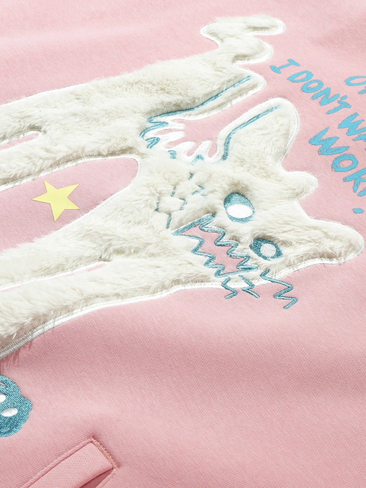 The Seakoff "Oh No! I Don’t Want to Work!" Oversized Graphic Hoodie features a pink fabric with an embroidered, textured lazy cat design, fuzzy white material, blue details, a yellow star, and partial text reading "I DON'T WANT TO WORK," ideal for casual streetwear.