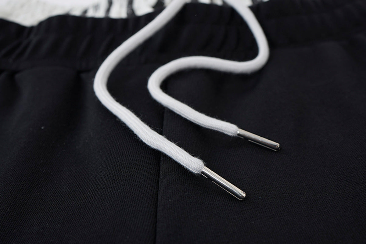 Pantalon de survêtement ample à jambes larges avec bandes latérales, fausse double ceinture et imprimé graphique